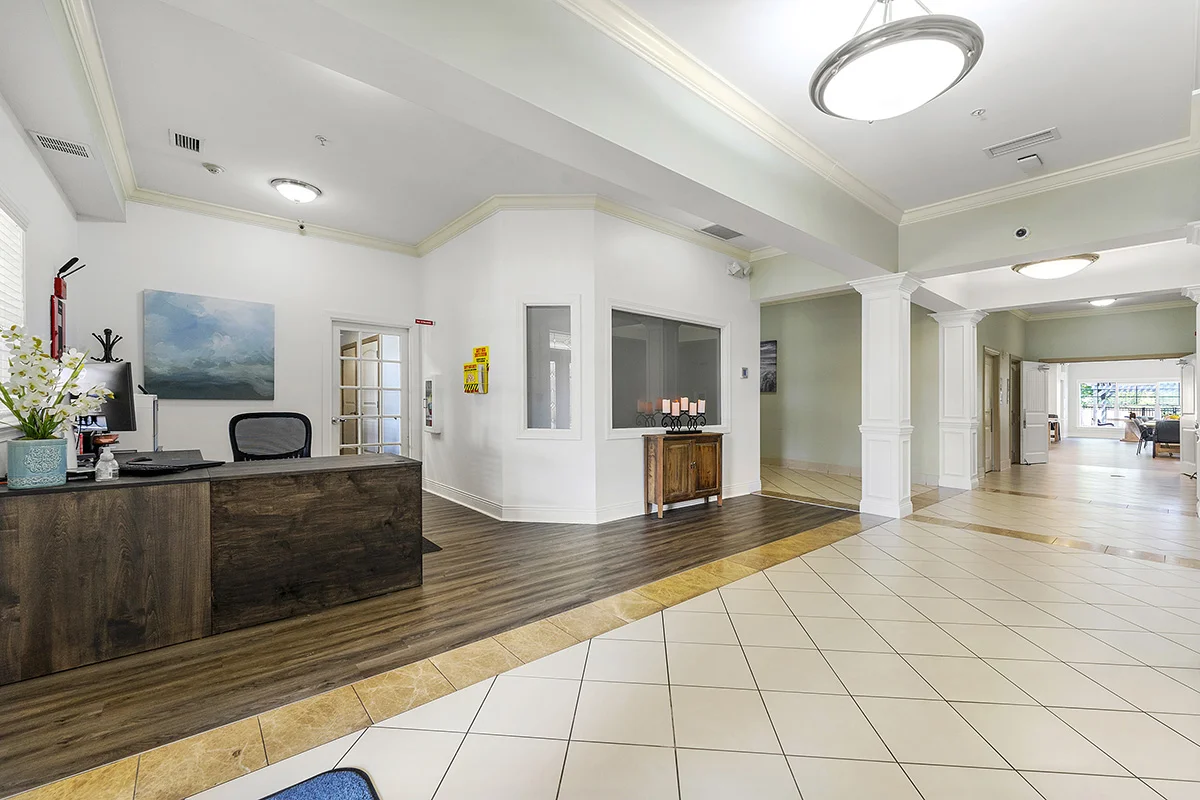 a lobby with a reception desk and a wood table