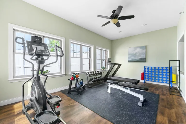 a room with exercise equipment and a fan