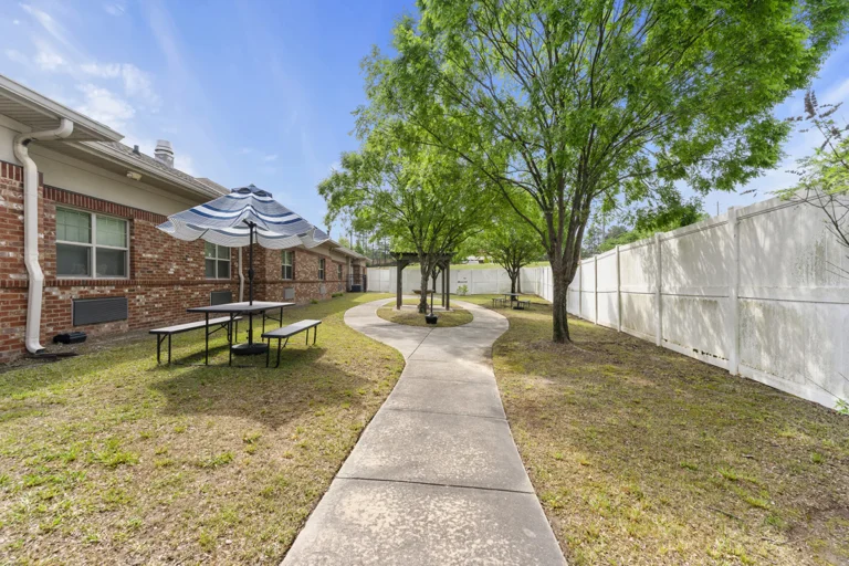a walkway with tables and umbrellas in a courtyard