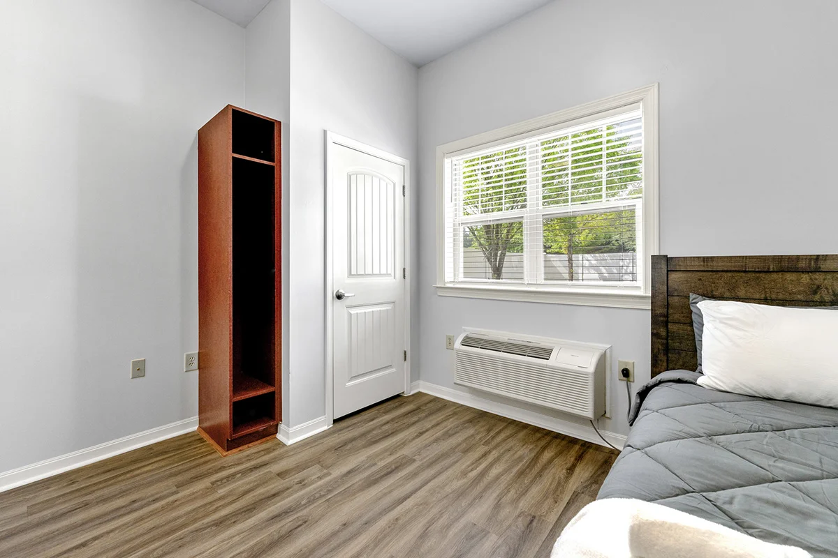 a room with a wood floor and a window