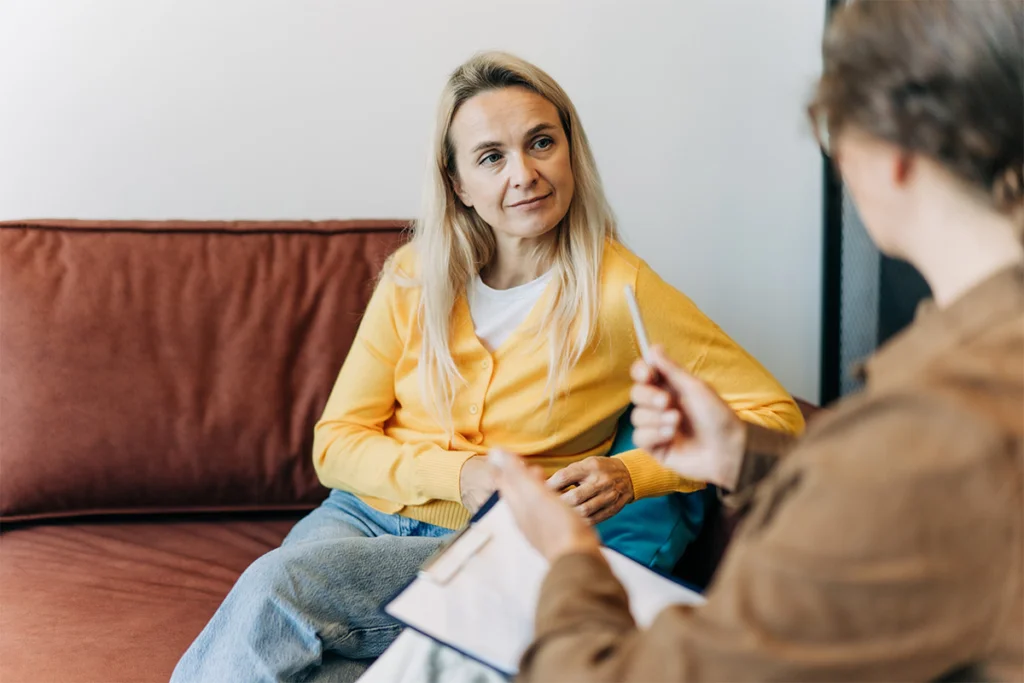a woman sitting on a couch talking to a man
