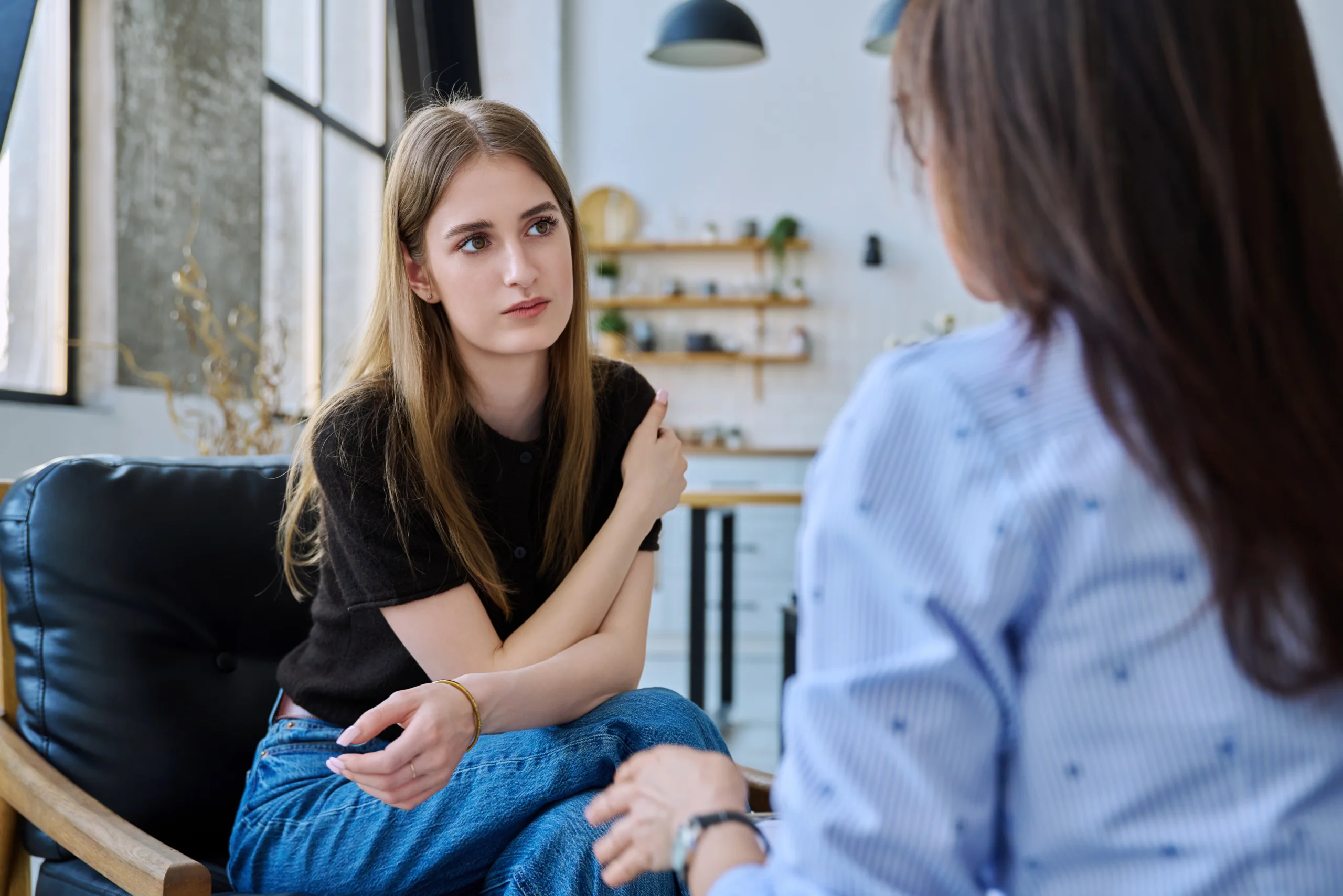 Two women engaged in serious conversation about heroin and opioid addiction