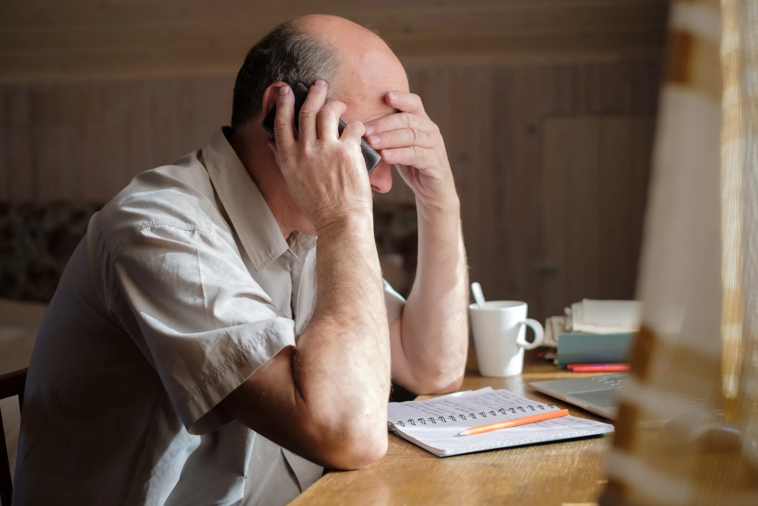 Man in distress at a table thinking about cocaine addiction signs