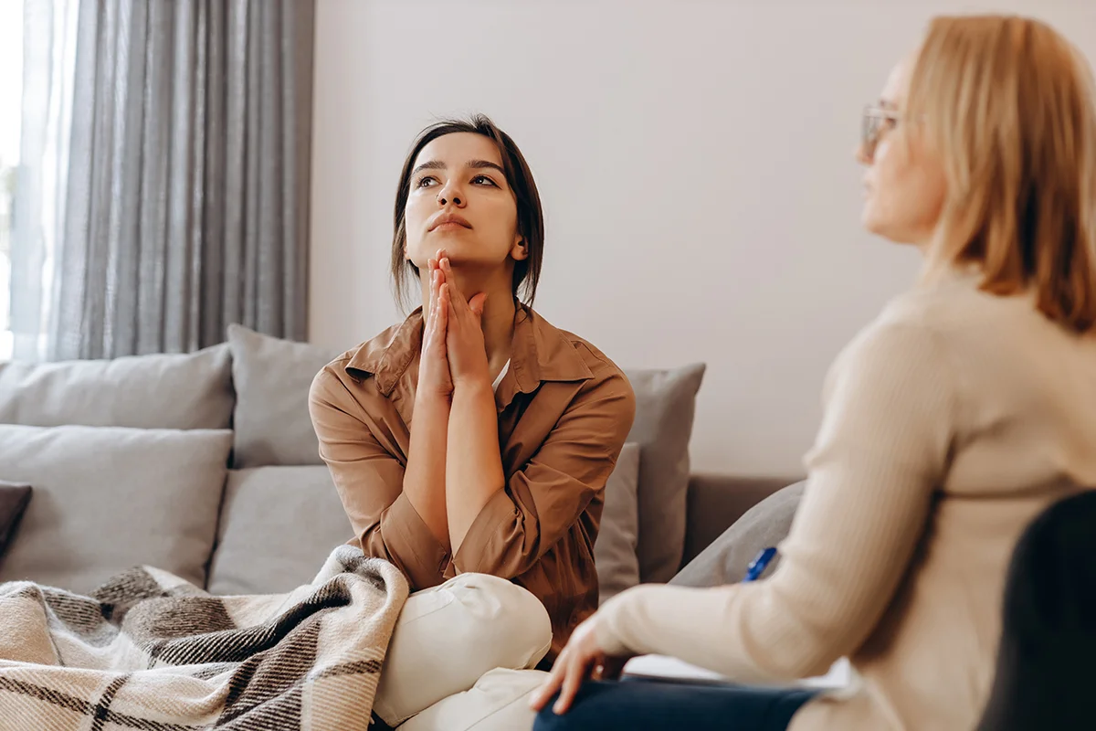 Two women engaged in conversation discuss marijuana addiction