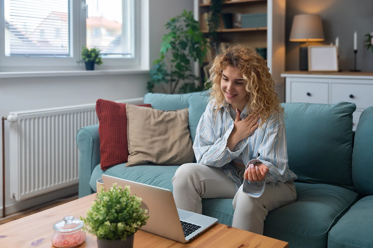 Person sitting on couch with laptop talking to provider about meth addiction